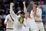 Australia players celebrate in a group after winning the fourth Ashes Test