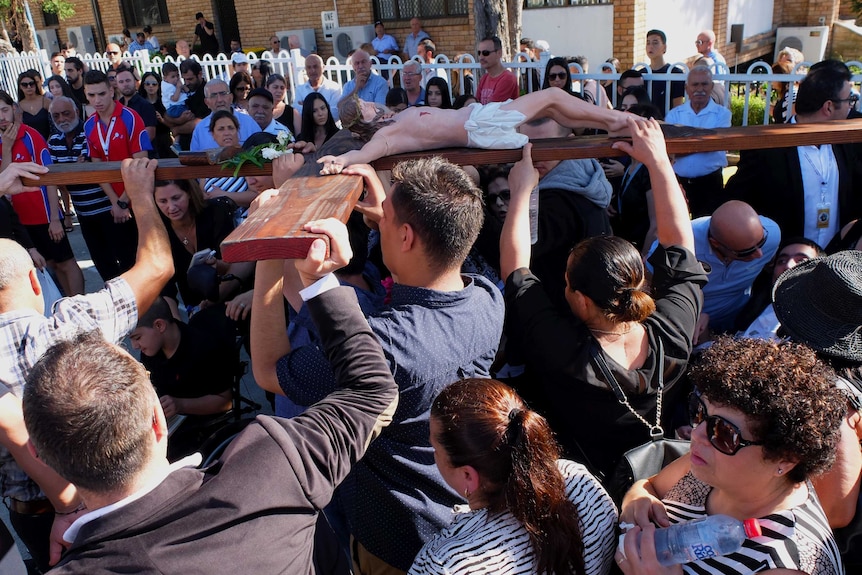 Maronite Catholics carrying Cross depicting Jesus's crucifixion.