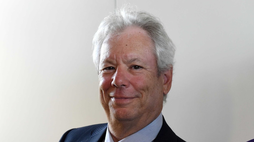 A portrait of US economist Richard Thaler wearing a suit.