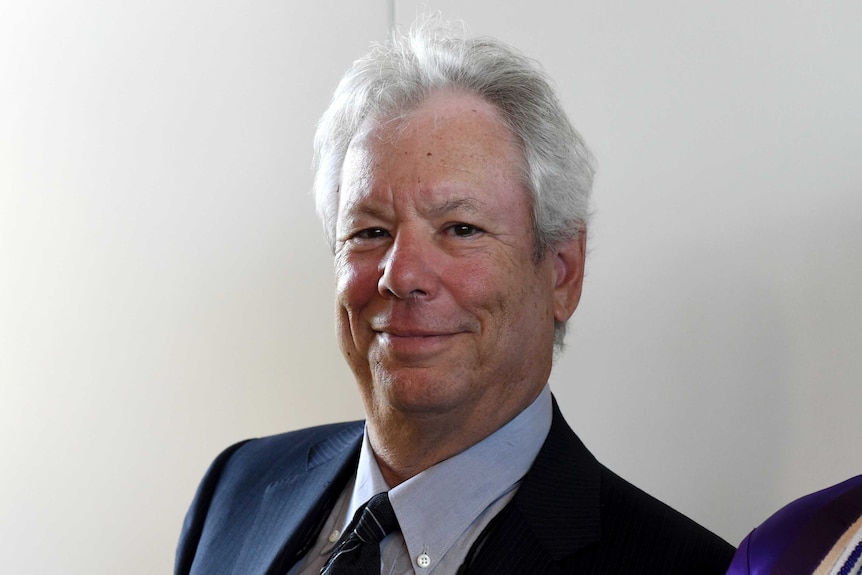 A portrait of US economist Richard Thaler wearing a suit