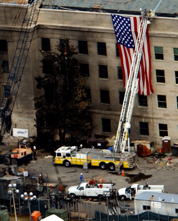 A zoomed-in version of the scene showing a fire truck and workers beside the building