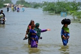 People wade through floodwaters