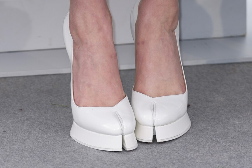 A close up of Greta Gerwig's white shoes, which have splits down the toe, almost looking like a hoof