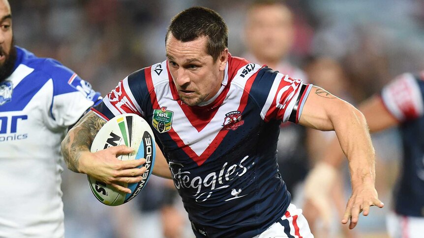 The Roosters' Mitchell Pearce breaks a tackle from Bulldogs' Josh Jackson in NRL round 10, 2015.