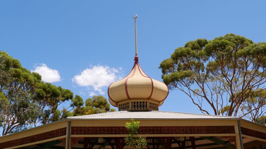 A cream coloured gazebo with a rotunda and a crescent moon on top