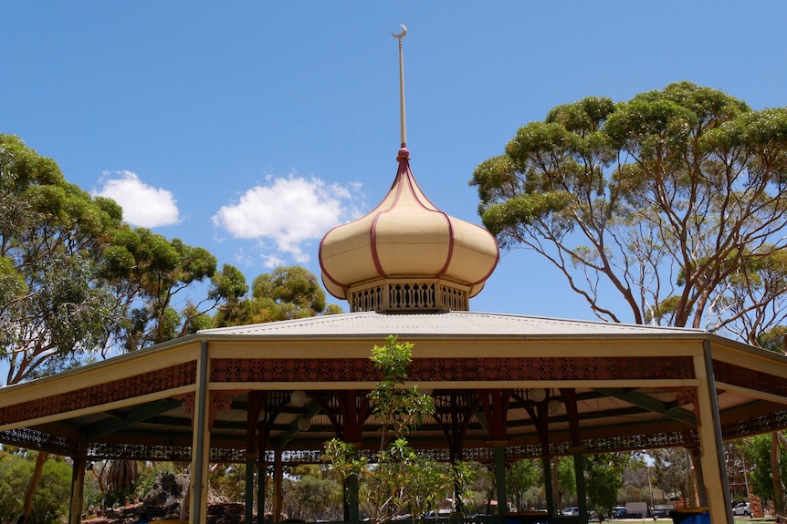 A cream coloured gazebo with a rotunda and a crescent moon on top