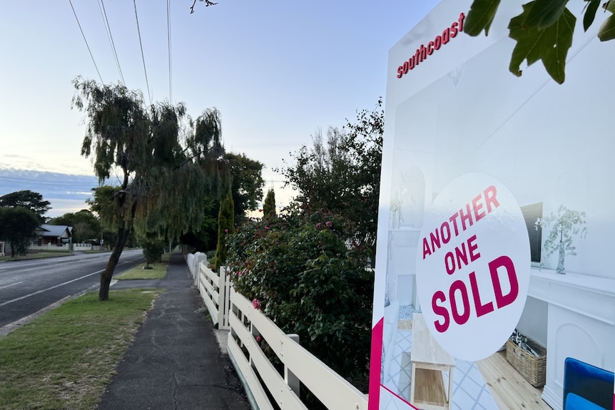 Pink text on a real estate property sign reading 'another one sold'