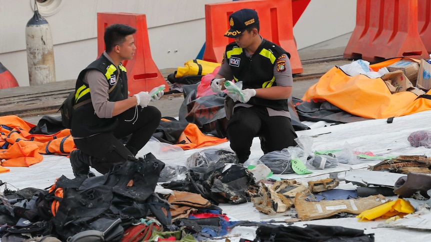 Officials inspect personal belongings retrieved from the waters where Lion Air flight JT 610 is believed to have crashed.