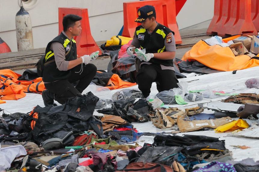 Officials inspect personal belongings retrieved from the waters where Lion Air flight JT 610 is believed to have crashed.