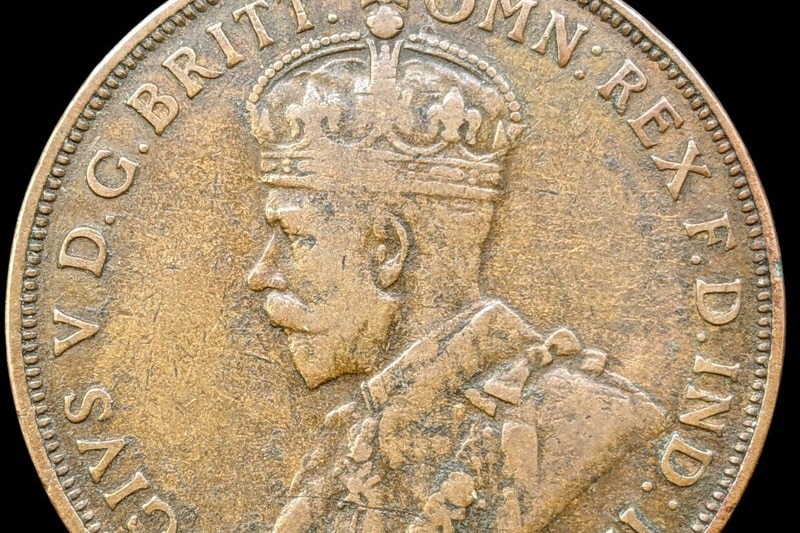A gold coin with the side profile of a man wearing a crown