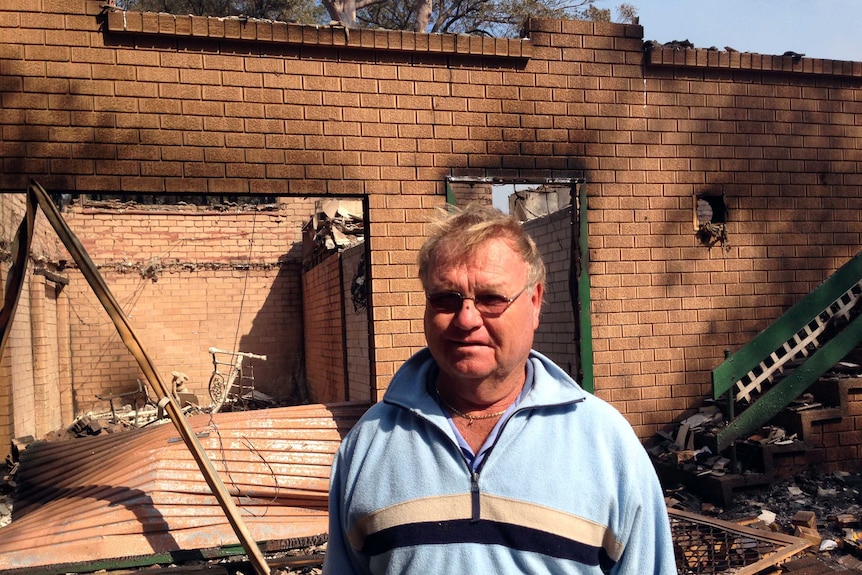 John Dowling surveys the remains of his home destroyed by a fire at Winmalee