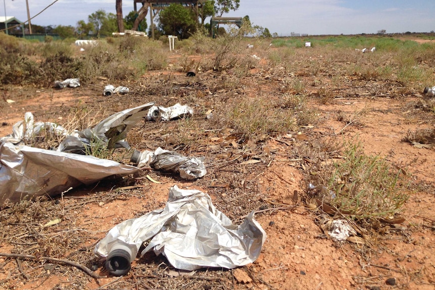 Wine casks left lying around in a desert landscape.