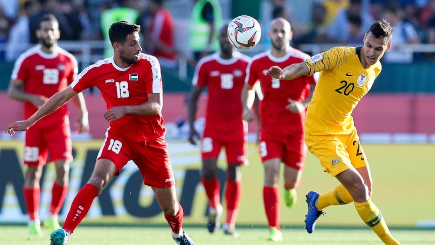 Trent Sainsbury vies for possession of the ball for Australia against Palestine