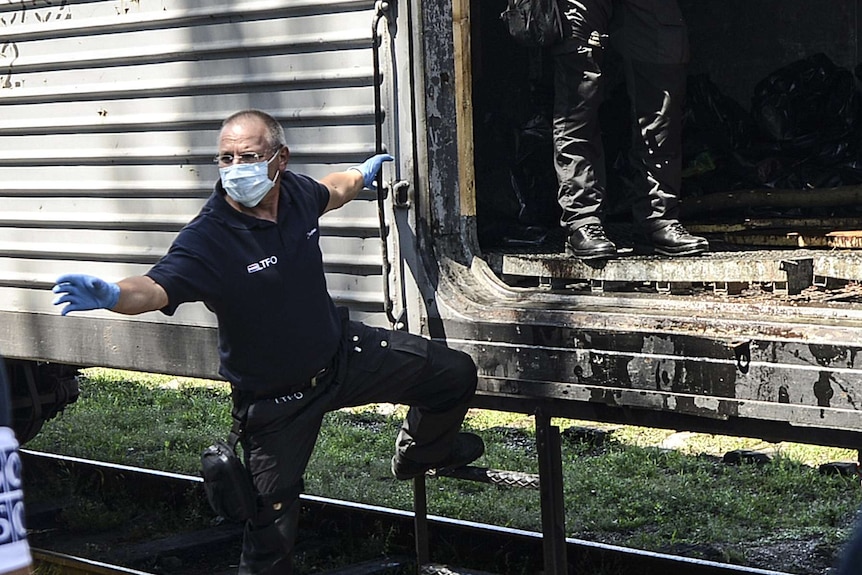 Dutch forensics experts board a refrigerated train in Torez, Ukraine to examine bodies of victims of the Malaysia Airlines MH17 disaster