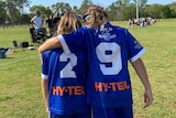 Junior girls soccer teammates walk arm-in-arm off the field in Darwin.