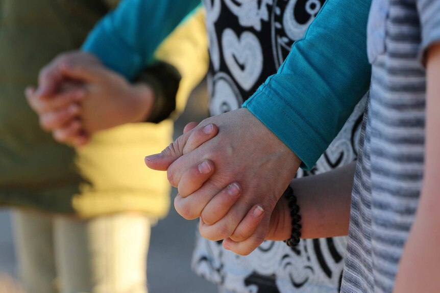 Close up of unidentified family members holding hands