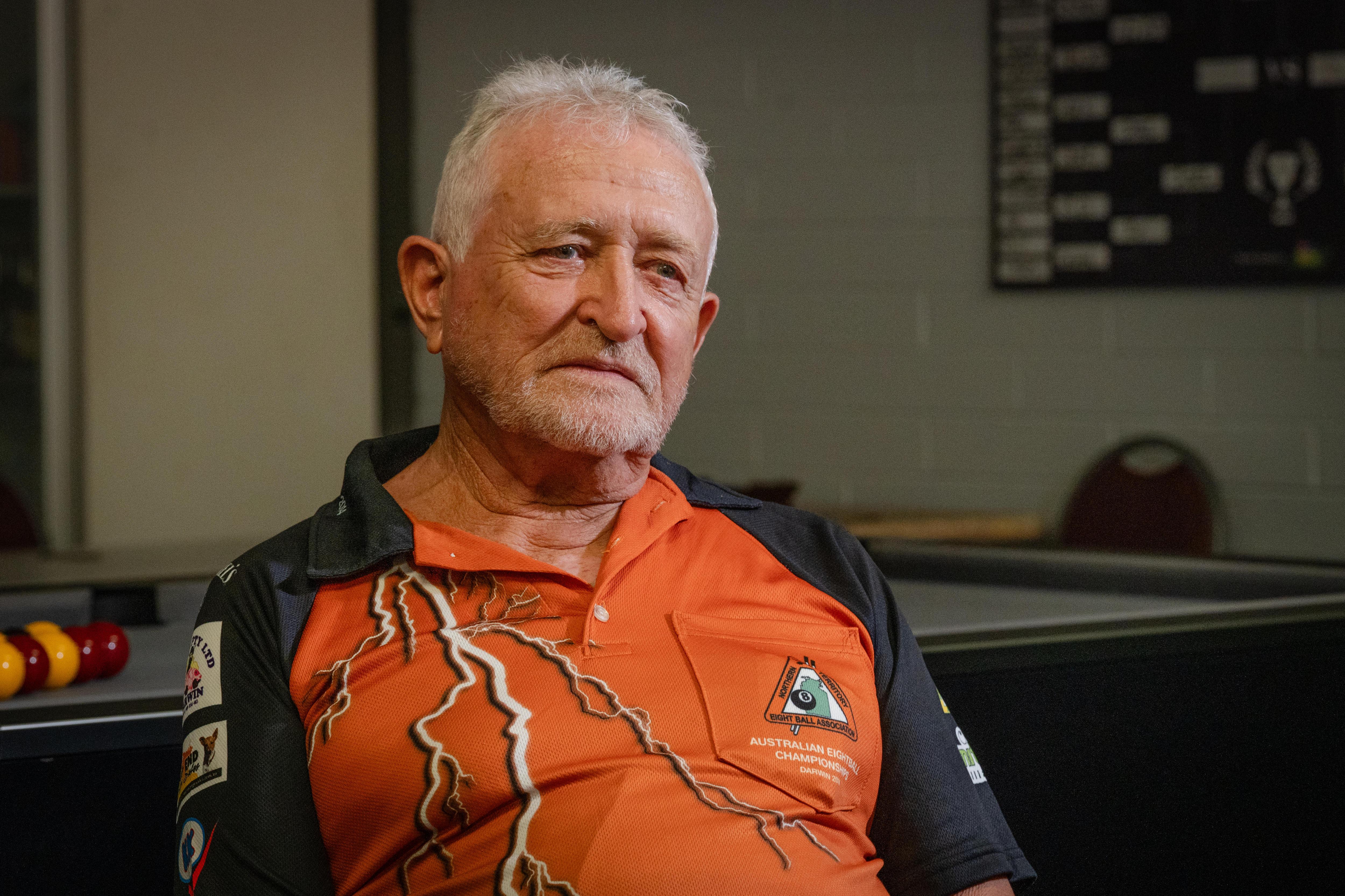 Ken Kernich wears a polo shirt with the Northern Territory Eight Ball Association logo, a pool table is in the background.