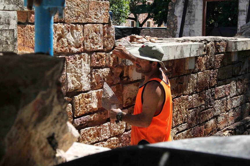 a man with stone on a building site