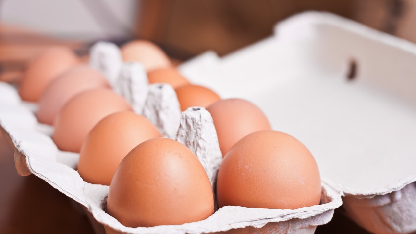 A dozen eggs sitting in a carton