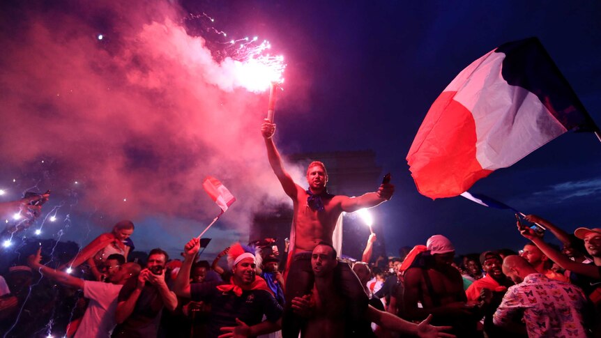 France fans with flares celebrate in front of the Arc de Triomphe