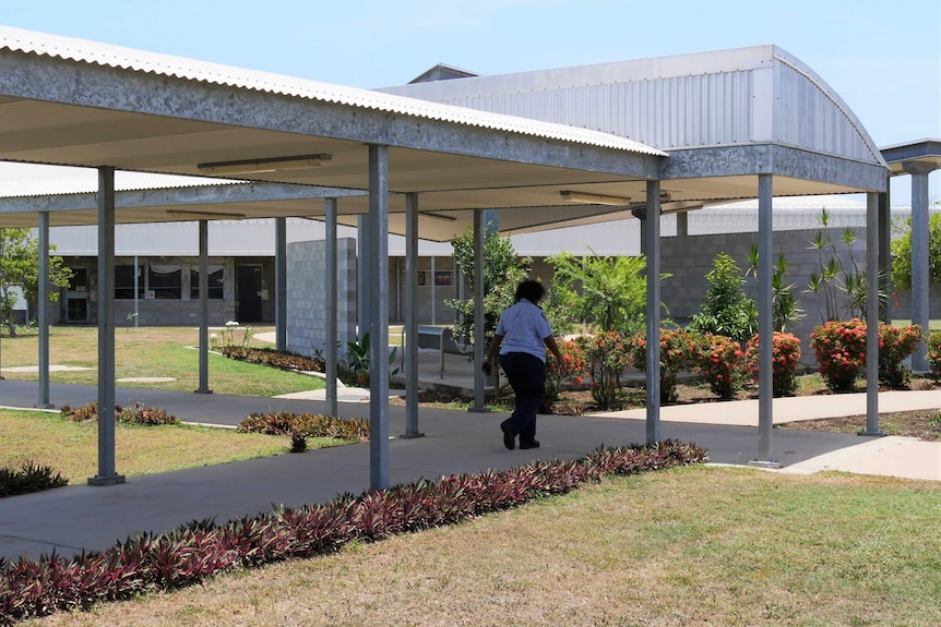 A female prison officer walks in the outdoor seating area of the Townsville Female Correctional Centre