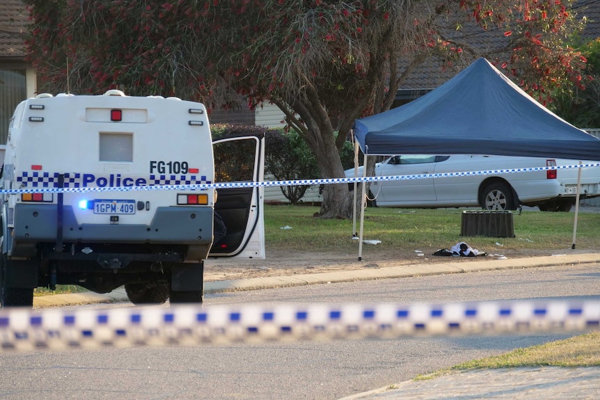 A street cordoned off by police tape with a police ute on the road with its door open and a pop-up canopy on a verge.