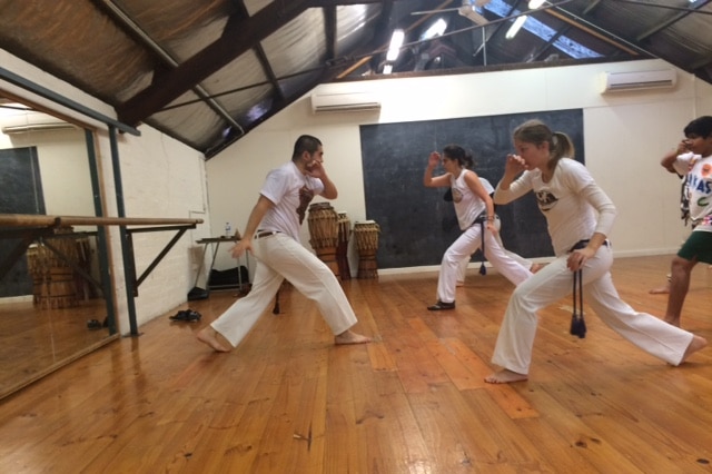 Capoeira performers in the fundamental move: ginga