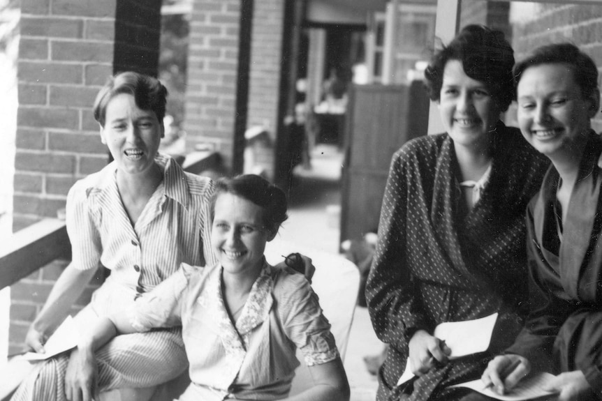 Black and white photo from 1945, smiling nurses out of uniform on a veranda