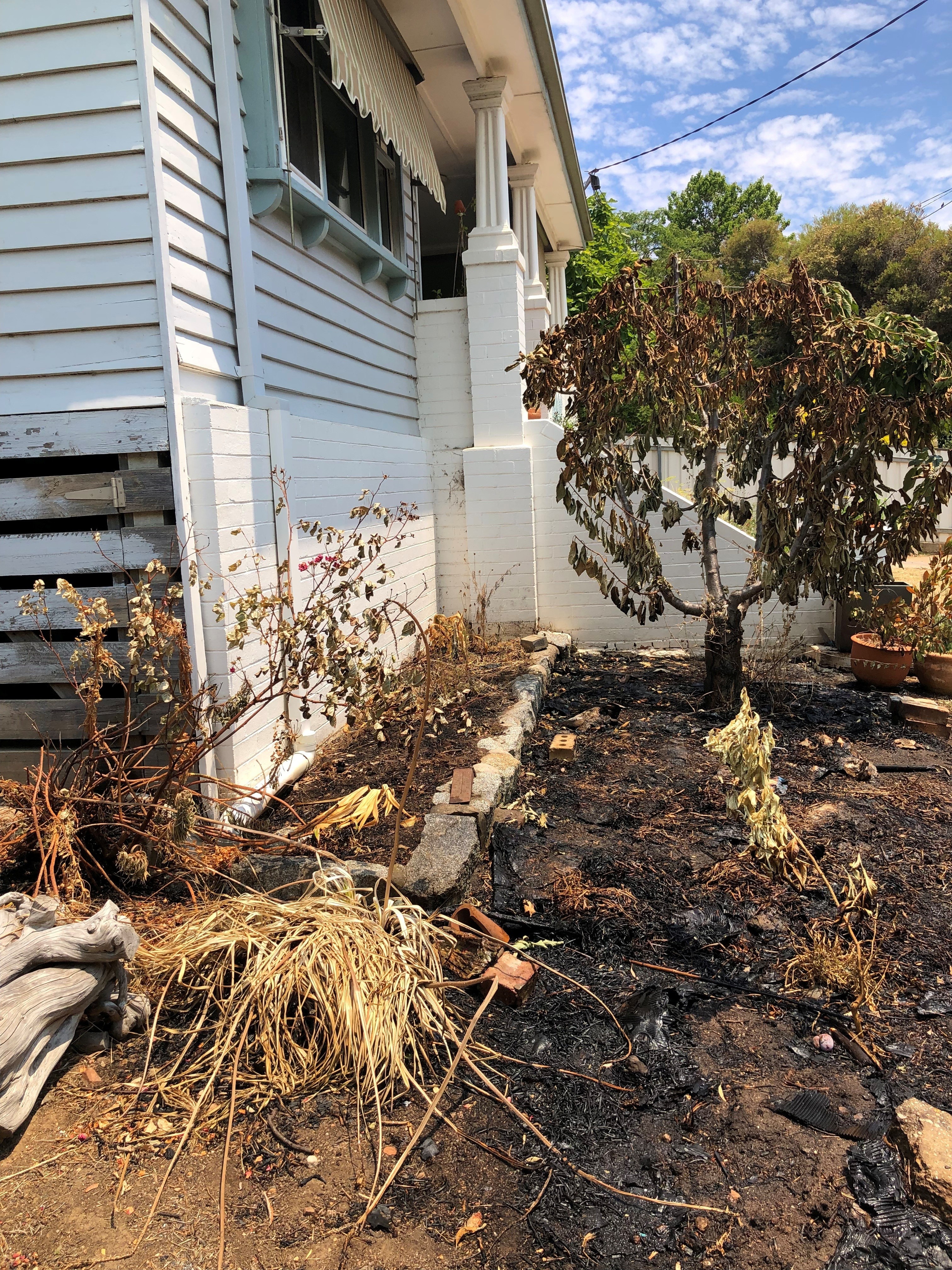 Danos causados ​​por um incêndio florestal no quintal de uma casa em Harcourt, região de Victoria.