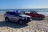 Police and lifeguard vehicles on a beach.