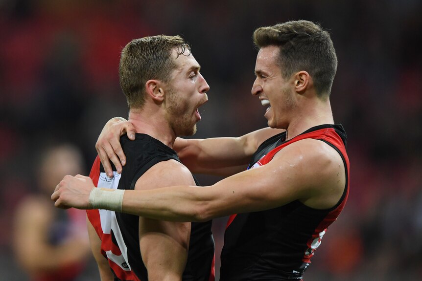 Orazio Fantasia gets hugged by Devon Smith after scoring an Essendon goal against GWS.