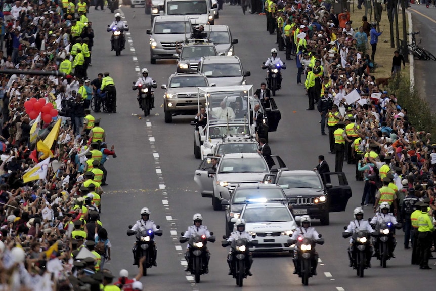 Pope Francis greets the faithful from a popemobile in Quito, Ecuador