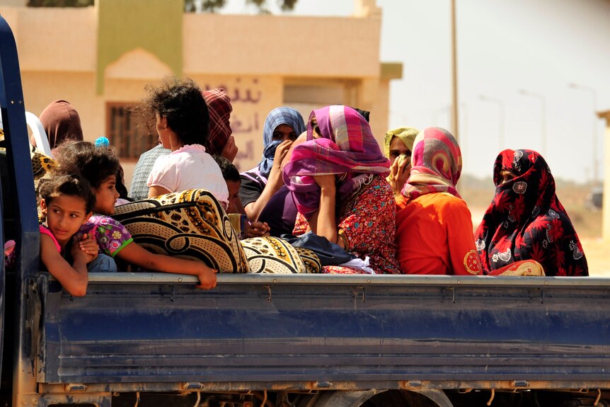 Civilians fleeing Sirte arrive in a truck at Khamseen Gate, 50 km east of Sirte, September 25, 2011.