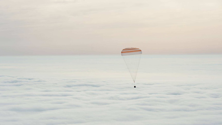 Spacecraft floats in the clouds towards earth