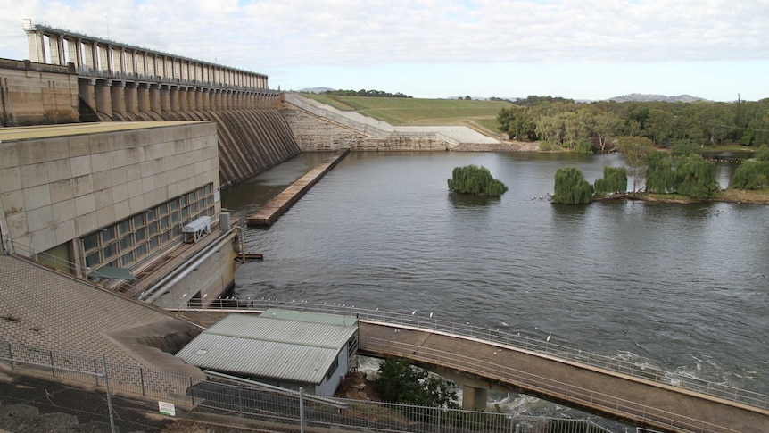 Concrete wall runs across a lake.