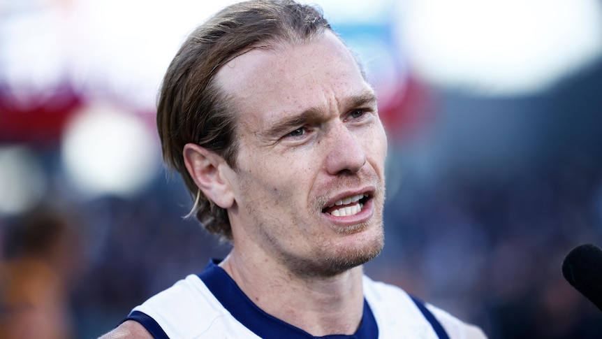 A close up Tom Stewart speaking while in his Geelong jersey