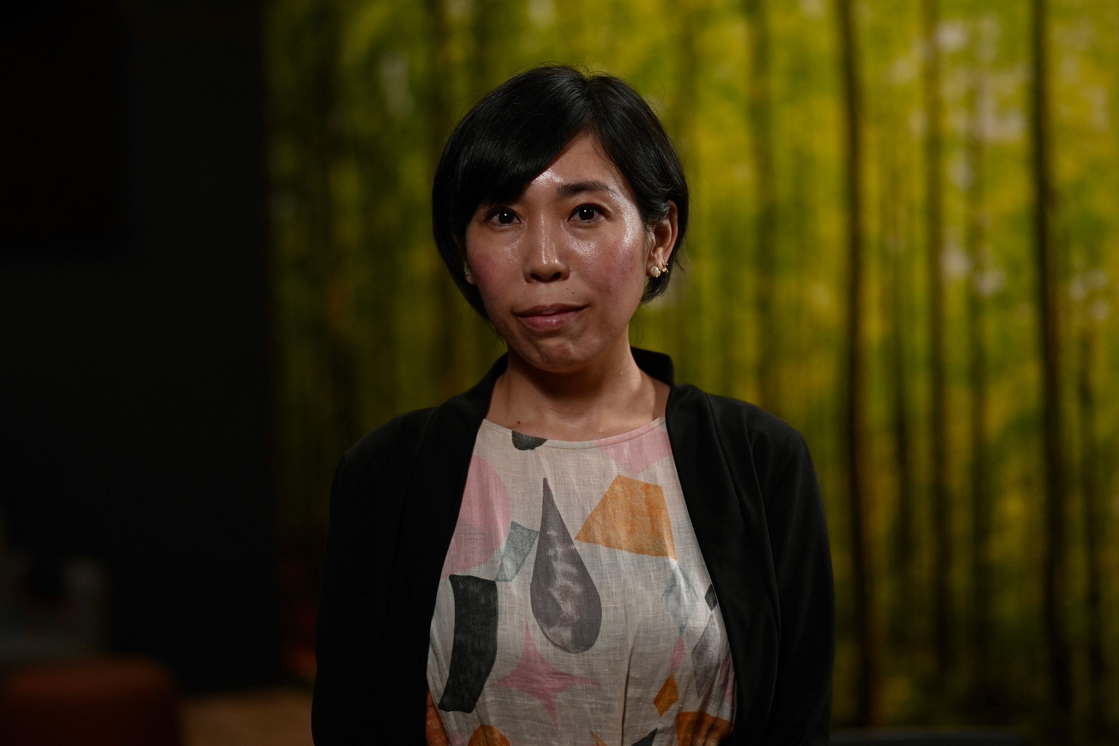 Lady stands in a dark room after an interview with ABC journalist Nassim Khadem