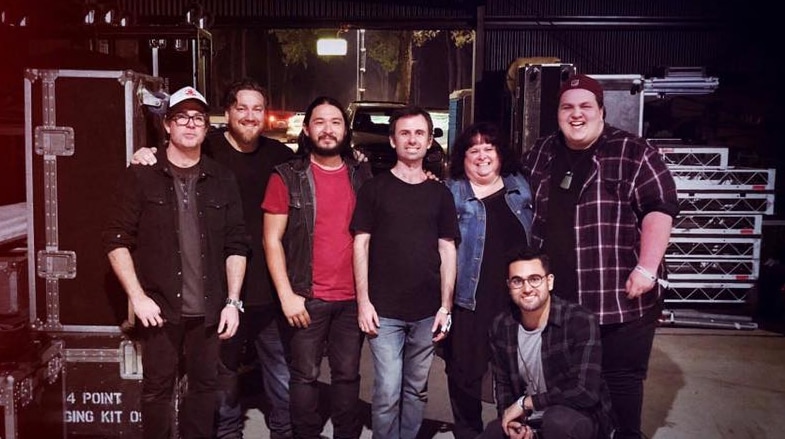 Judah Kelly and his band behind mainstage, smiling after a set they played in Gympie