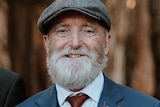 A man wearing a suit with a grey beard