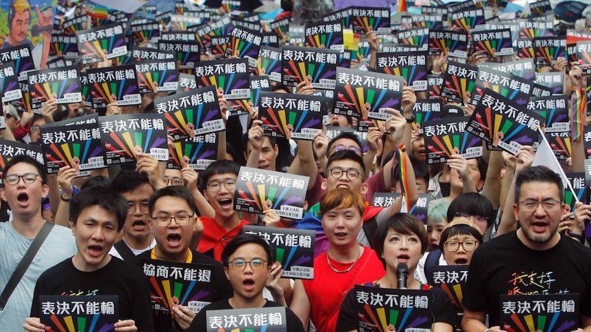 Para pendukung pernikahan sesama jenis berkumpul di Taiper dengan poster bertuliskan “Hasil pemungutan suara bisa dikalahkan”.