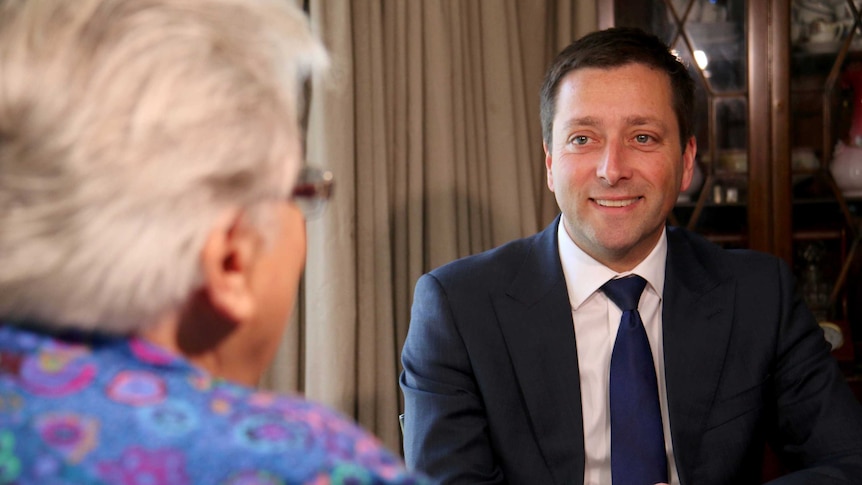Matthew Guy smiling at Joyce Currie across a table.