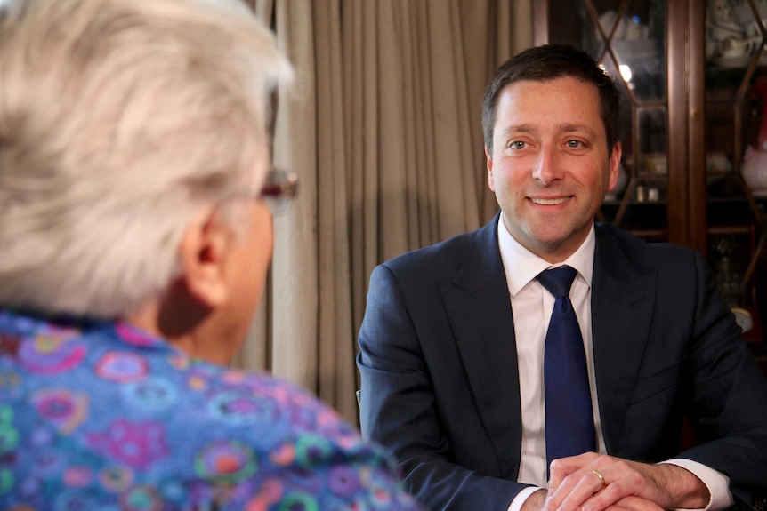 Matthew Guy smiling at Joyce Currie across a table.