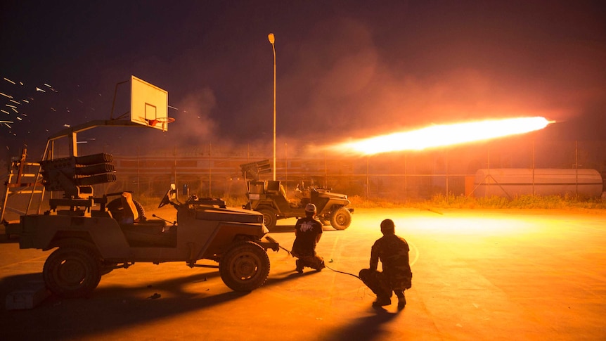 Shiite fighters fire a rocket during clashes with Islamic State