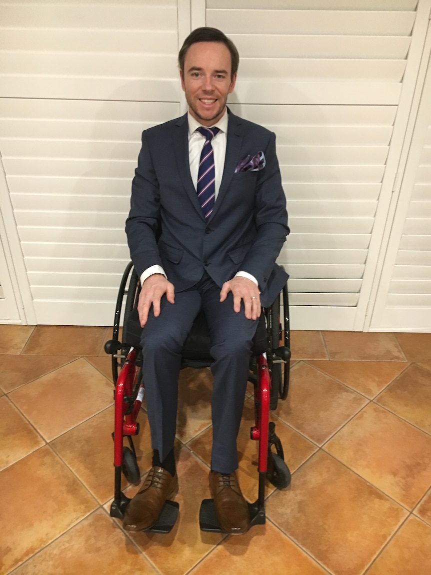 A man sits in wheelchair wearing a suit