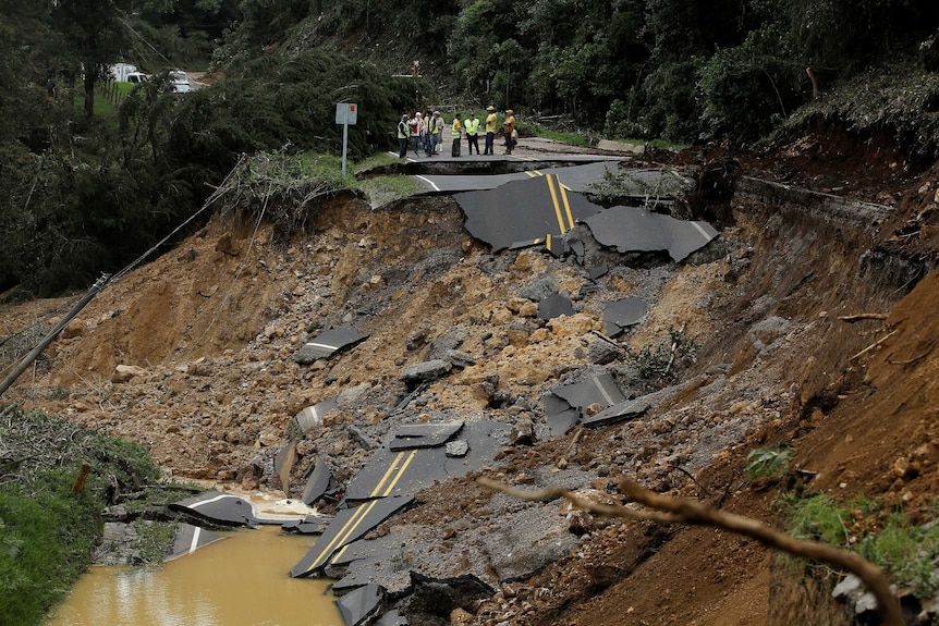 A wide photograph shows a road completely disintegrated along a hill in Costa Rica.