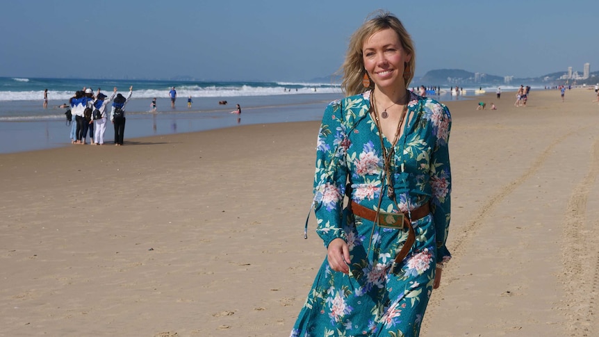 Woman with blonde hair walk on crowded beach