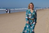 Woman with blonde hair walk on crowded beach