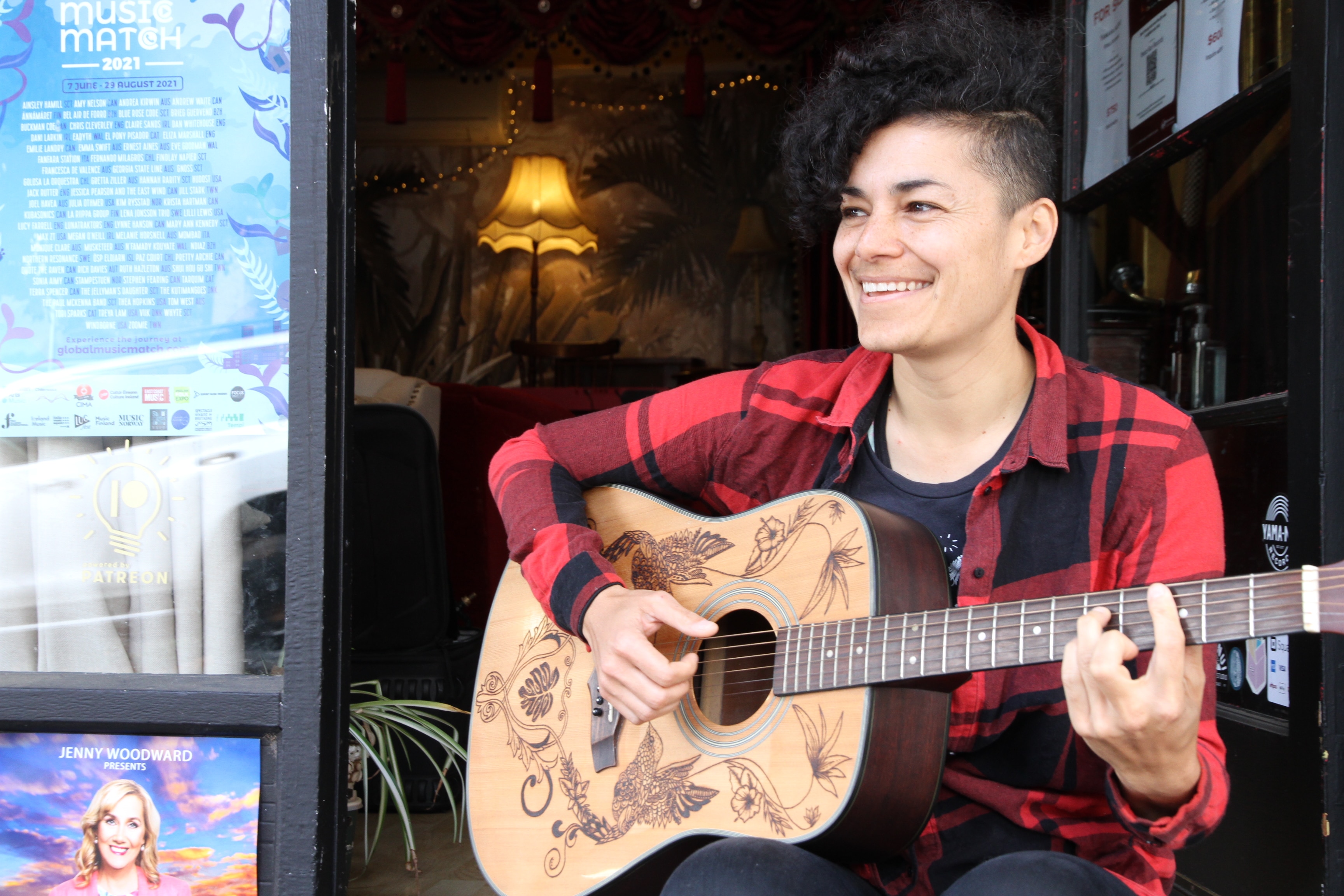 Andrea Kirwin sonríe mientras toca la guitarra.