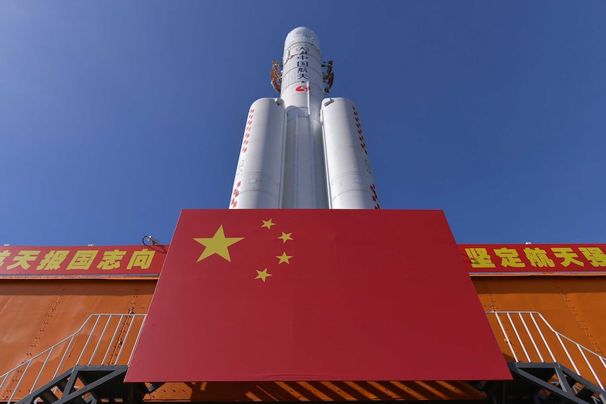 A Long March-5 rocket is seen at the Wenchang Space Launch Centre with a Chinese flag in front.