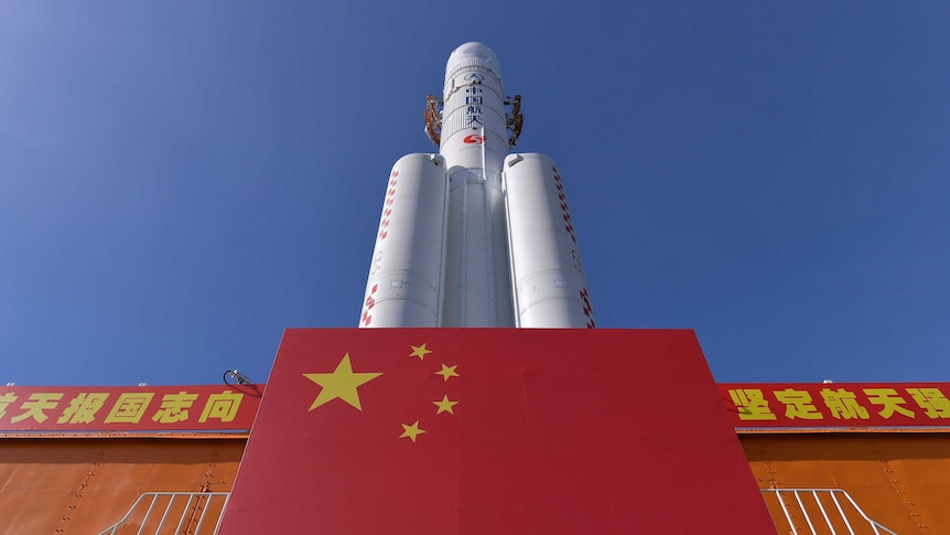 A Long March-5 rocket is seen at the Wenchang Space Launch Centre with a Chinese flag in front.